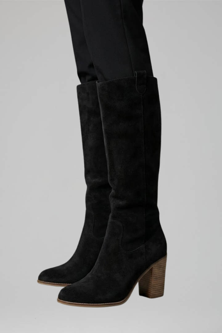 Black knee-high boots on a gray background