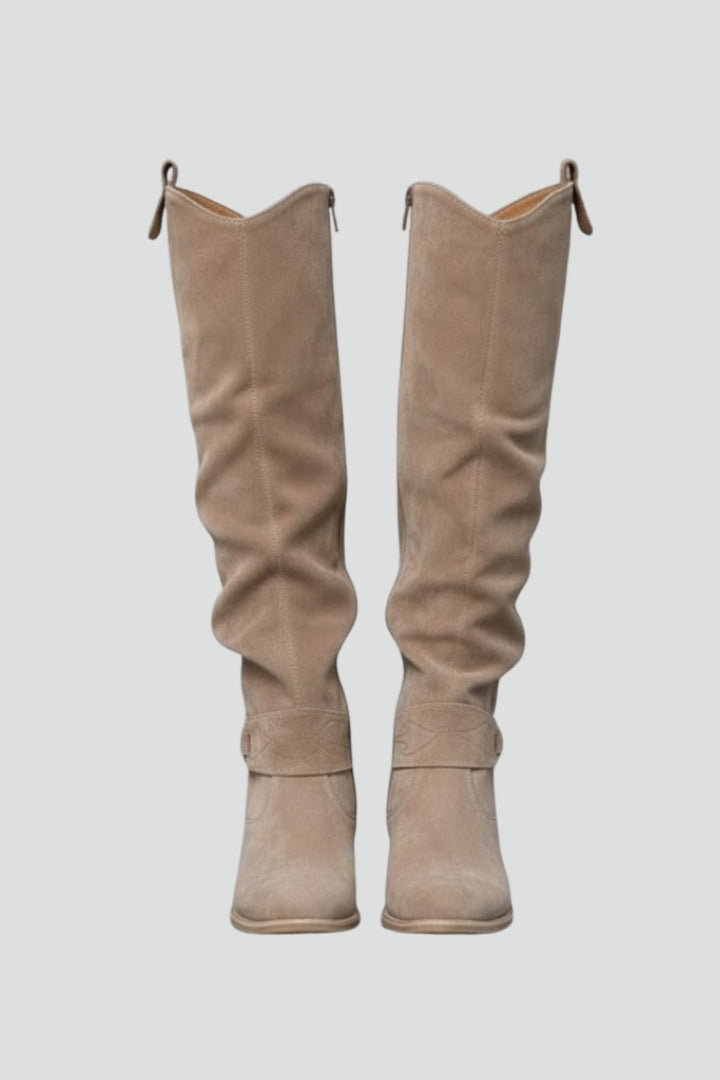 Pair of beige knee-high boots on a light gray background