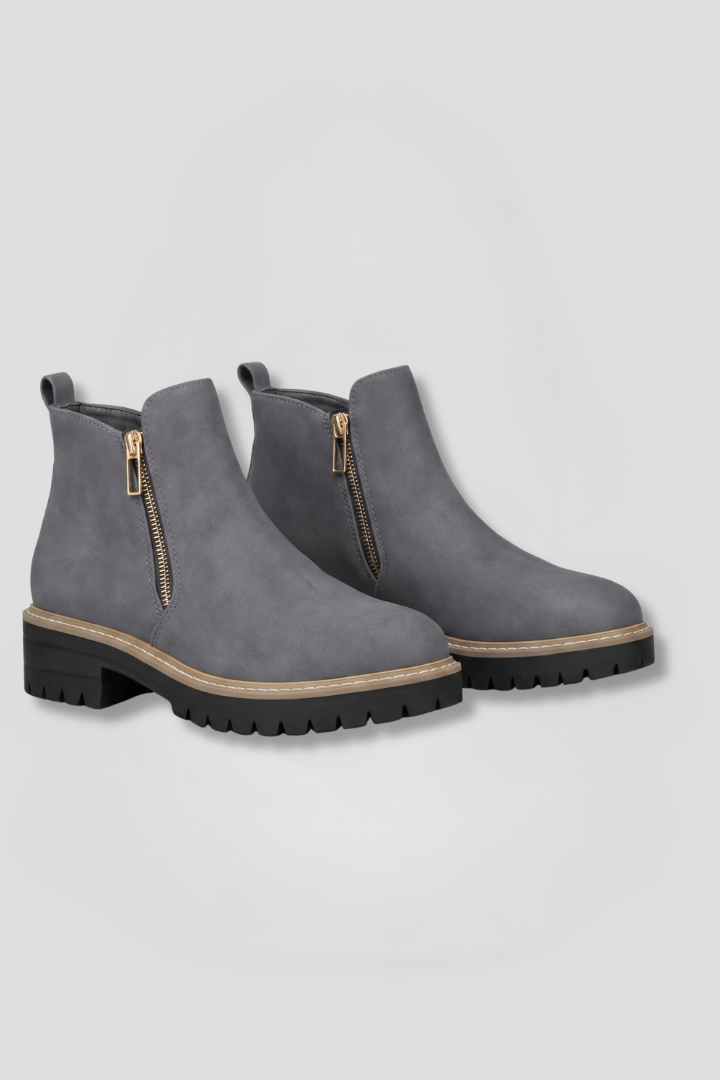 Gray ankle boots with zippers on a light gray background