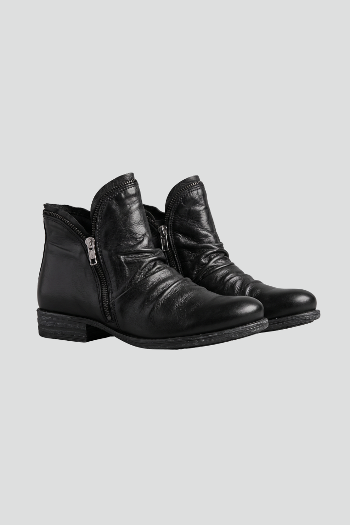 Pair of black leather boots on a light gray background