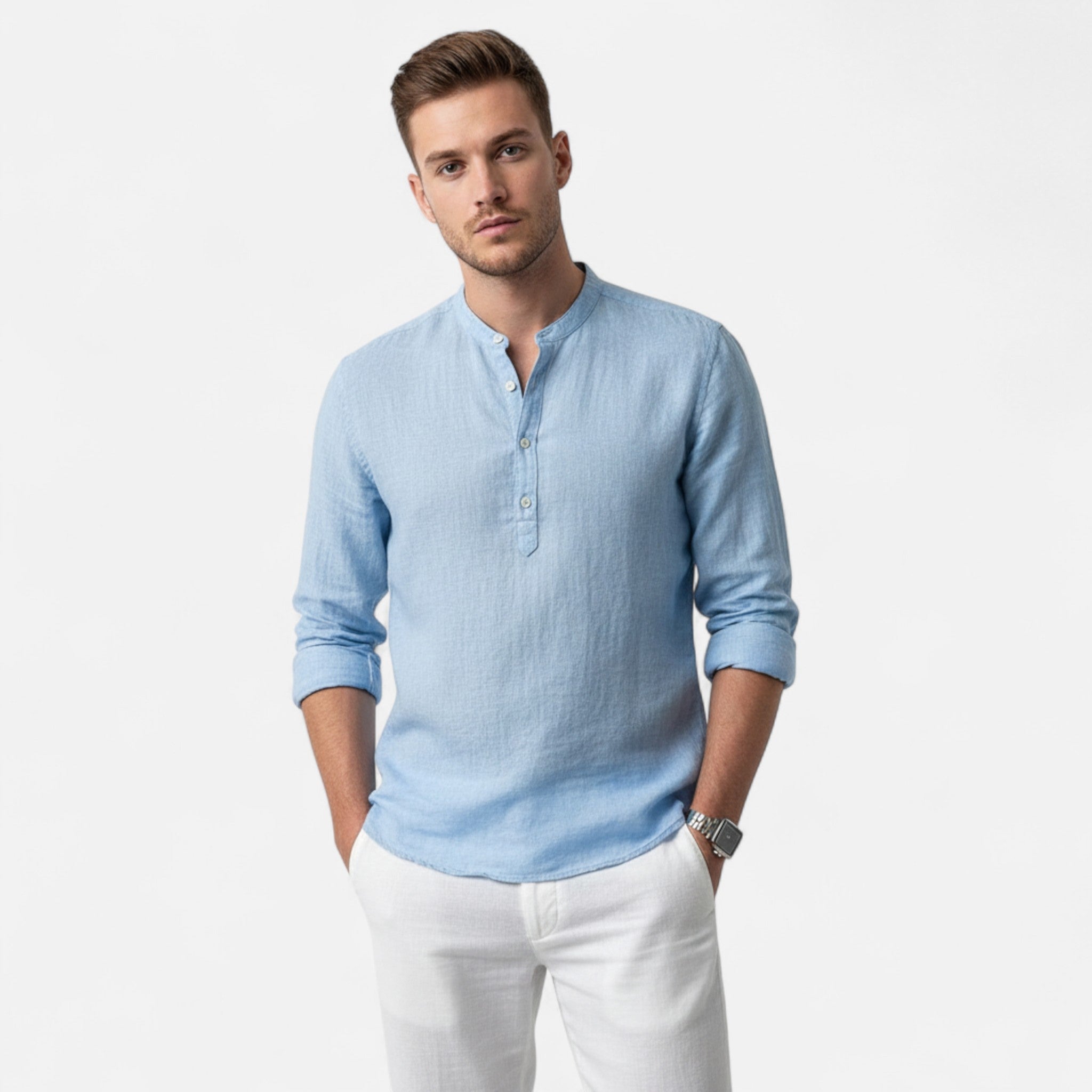 Man wearing a light blue long-sleeve shirt and white pants on a white background