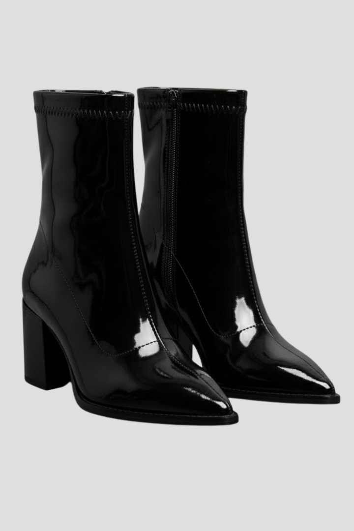 Black patent leather boots on a light gray background