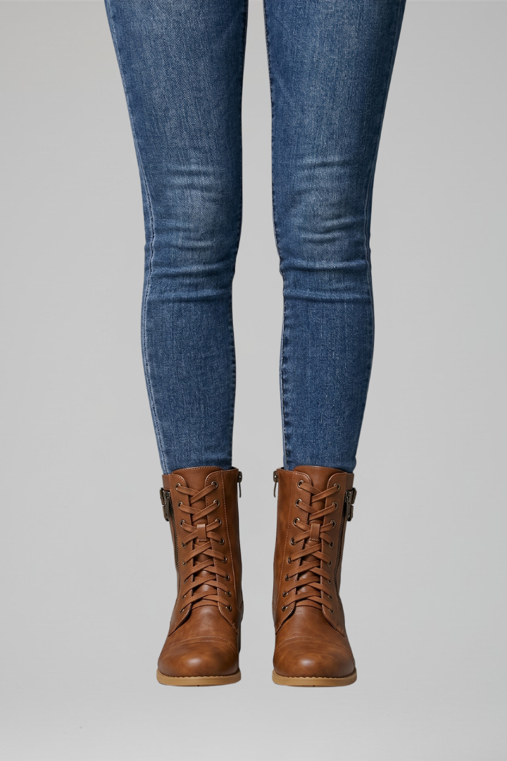 Blue jeans and brown leather boots on a gray background