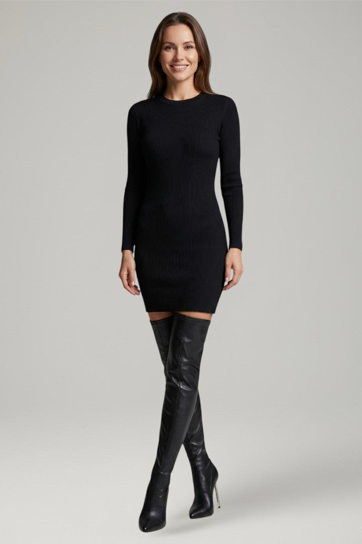Woman wearing a black dress and black knee-high boots on a gray background