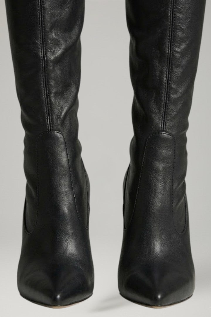 Black leather knee-high boots on a gray background
