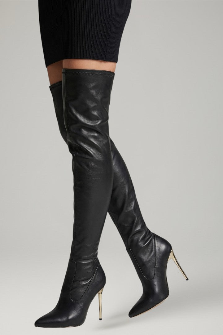 Black leather knee-high boots with high heels on a light gray background